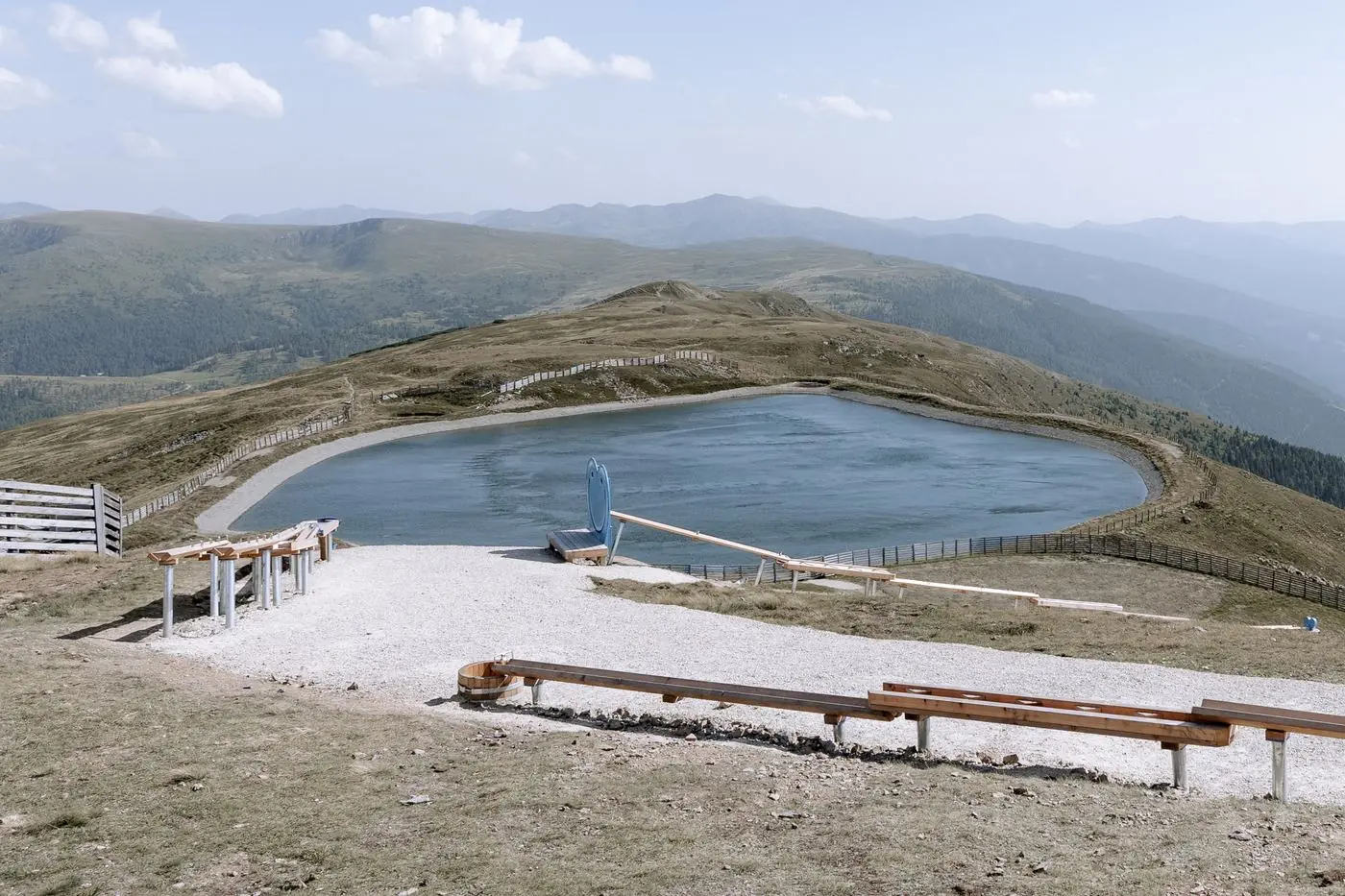 Bergsee mit Holzliegen neben Katschis Almspielplatz am Aineck, Katschberg im Sommer