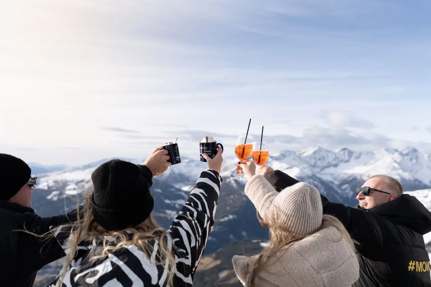 Anstoßen mit Getränken vor dem Bergpanorama am Katschberg