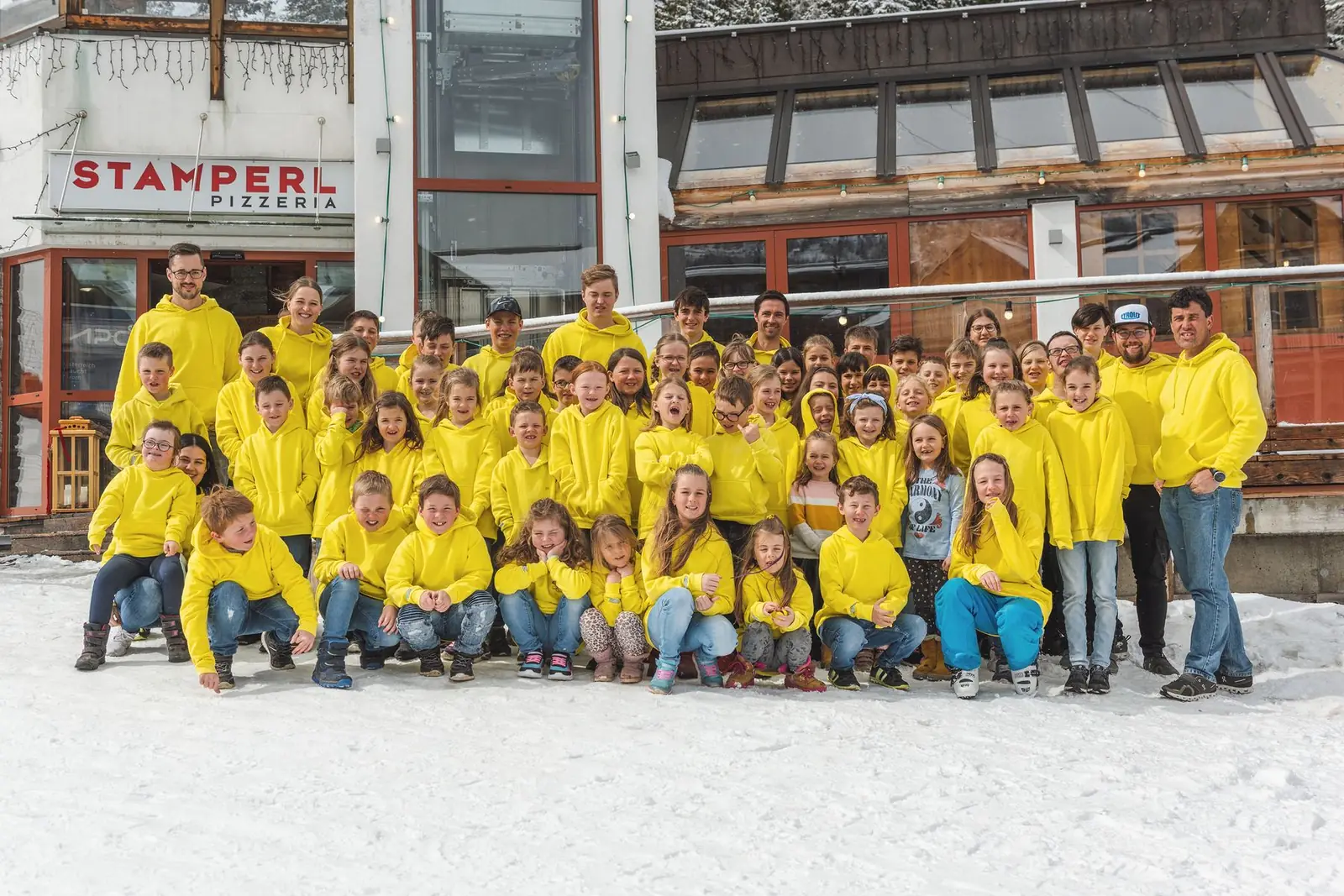 Gruppenfoto des Skiclubs Rennweg/Katschberg (SCRK) in gelben Jacken zum 80-jährigen Jubiläum