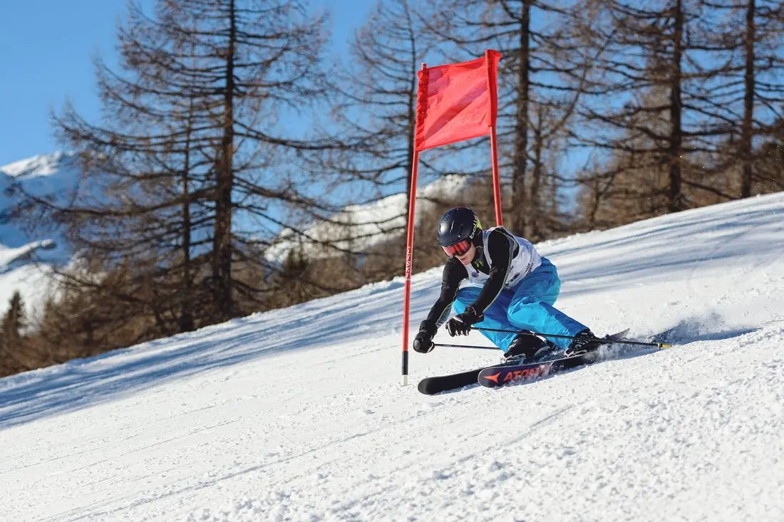 Rennläufer des Skiclubs Rennweg/Katschberg fährt an einer roten Torflagge vorbei