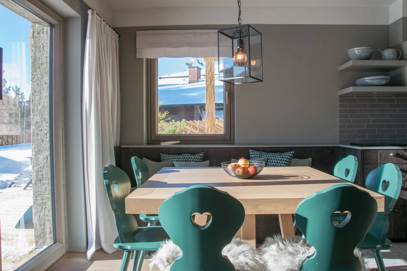 Essbereich mit grünen Herzstühlen im Kauz Chalet