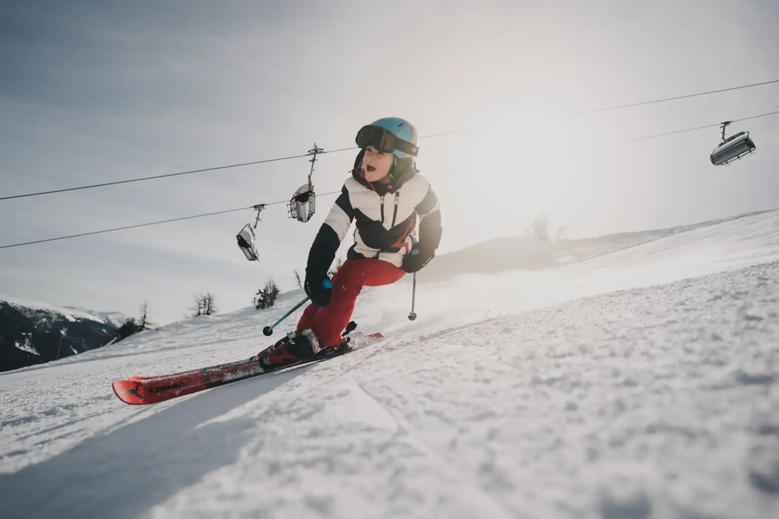 Kind carvt auf der Piste am Katschberg unter dem Sessellift