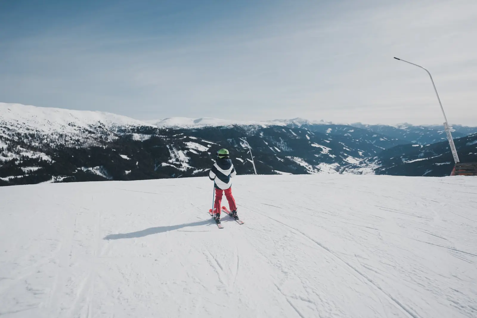 Kind auf Ski blickt über das Tal am Katschberg
