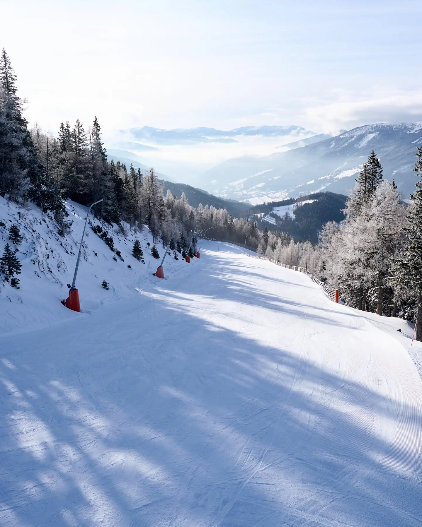 Präparierte Piste mit Schneilanzen und Blick ins Tal