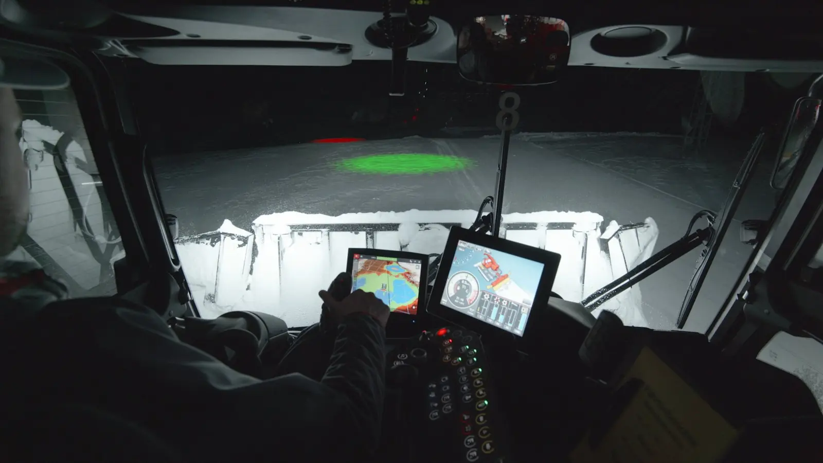 Blick aus der Fahrerkabine eines Pistengeräts bei Nacht auf die SNOWsat-Bildschirme