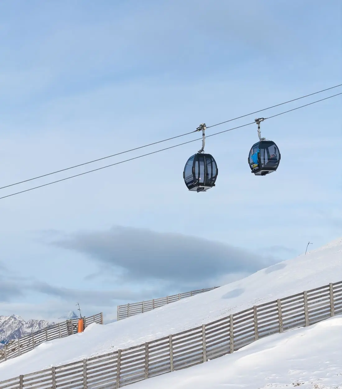 Zwei Kabinen der neuen Almbahn über der verschneiten Piste am Aineck, Katschberg