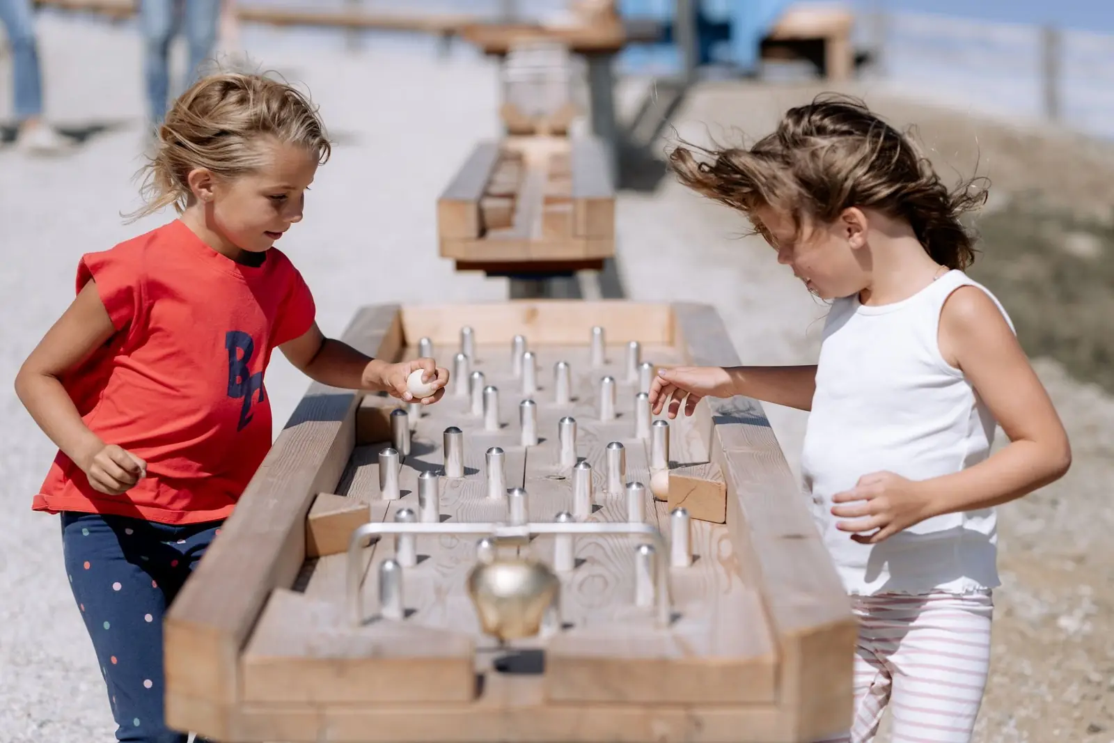 Zwei Mädchen spielen an der hölzernen Kugelbahn auf Katschis Almspielplatz am Aineck, Katschberg