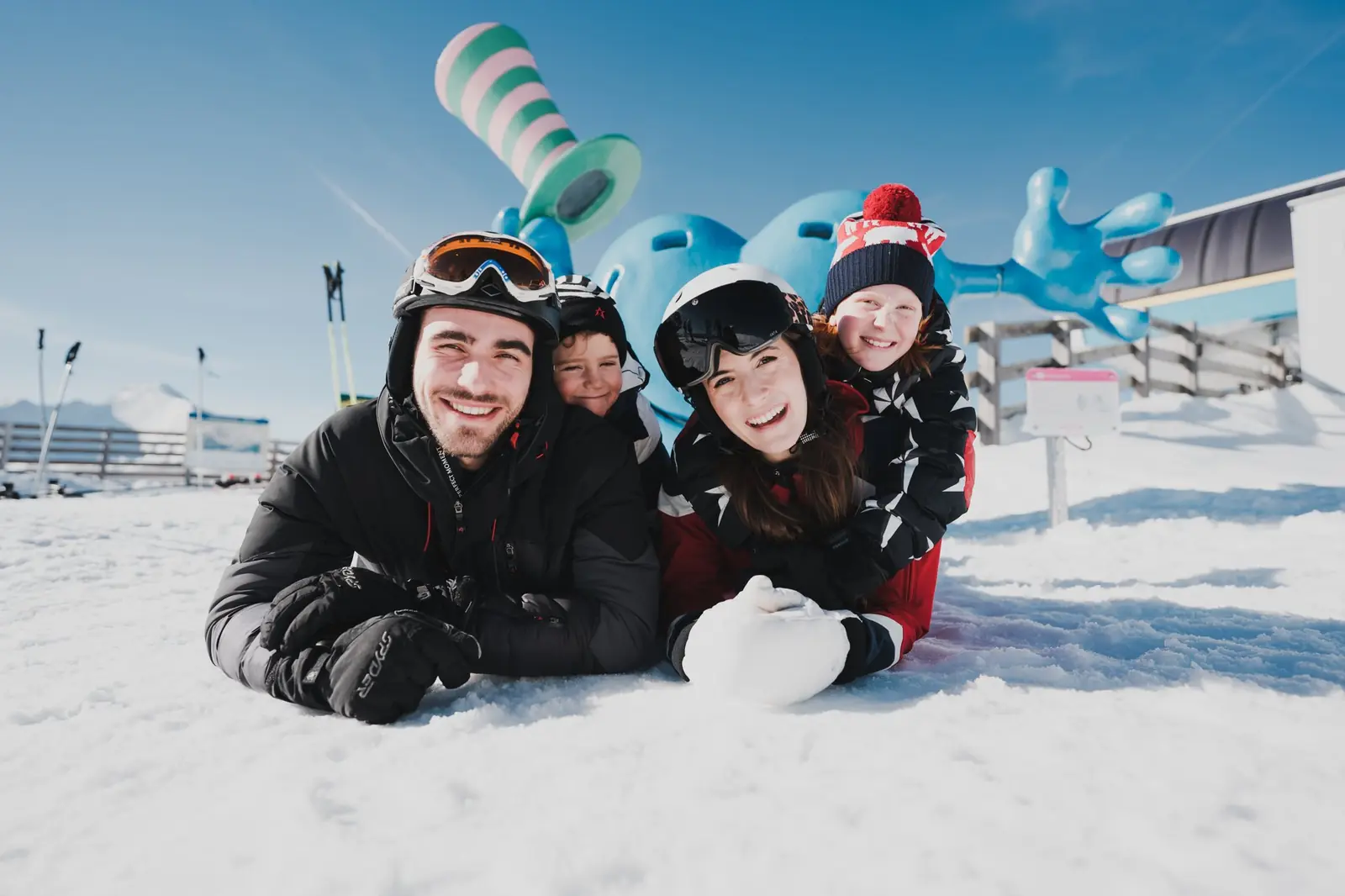 Familie im Schnee vor der Katschi-Figur am Katschberg